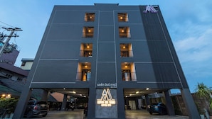A modern hotel with a prominent logo, multiple balconies, and a parking area. - North Inn Town (Chiang Mai)