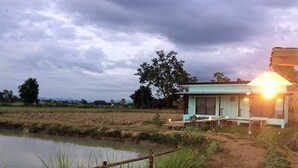 Uma casa rústica com uma janela grande, um alpendre e um espaço ao ar livre bem iluminado.