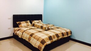 Um quarto com uma cama, uma cabeceira preta, uma parede azul e um aparelho de ar condicionado.