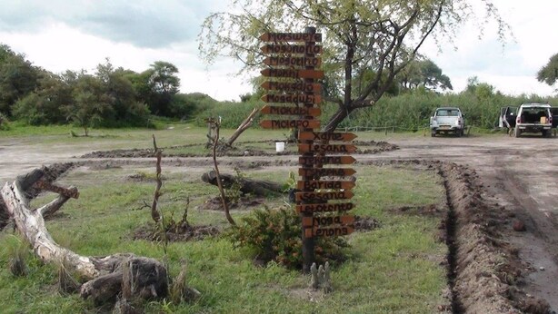 A directional signpost in a rural setting with multiple arrows pointing to various destinations. - Matsaodi Campsite (Rakops)
