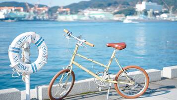 A bicycle parked next to a lifebuoy by a waterfront.