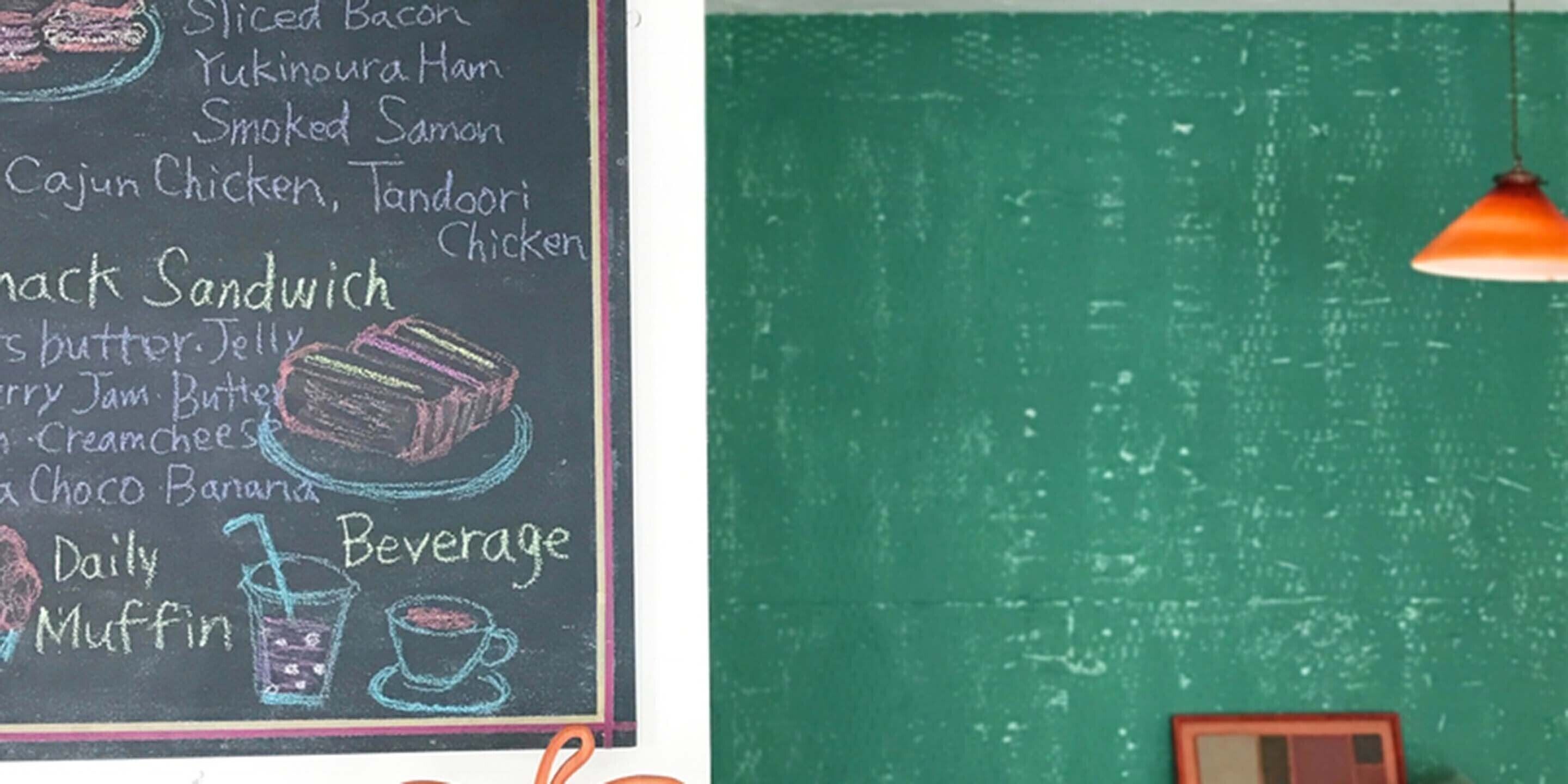Un tableau noir affiche le menu avec une liste de plats, notamment du bacon en tranches, du saumon fumé et du poulet cajun.