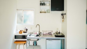 A compact kitchen with a microwave, sink, and a small countertop.