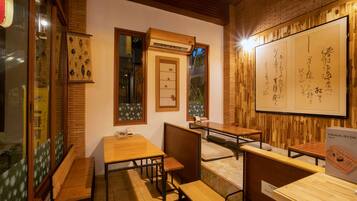 A traditional Japanese restaurant interior with wooden furniture, tatami mats, and calligraphy on the walls.
