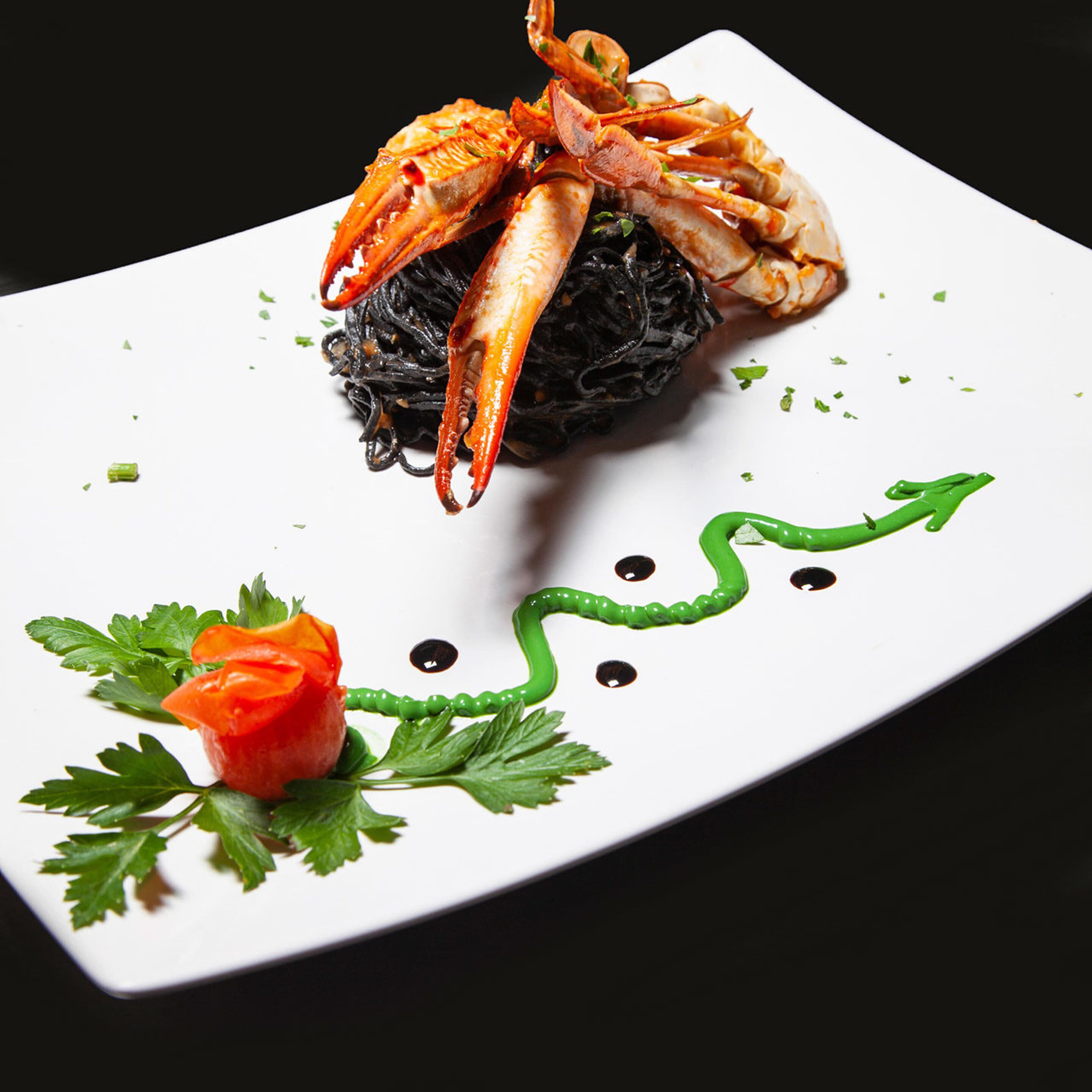 A seafood dish with a decorative garnish on a white plate.