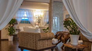 Ein gemütliches Wohnzimmer mit einem gewebten Sofa, einem Holztisch und einem Blumentopf.