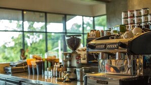 Une machine à café dotée d’un récipient en verre et d’un moulin à café, le tout posé sur un comptoir.