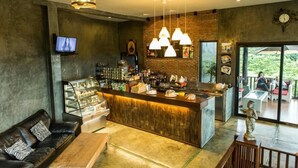 Un espace bar moderne doté d’un comptoir, de sièges et d’un téléviseur.