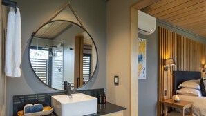 A modern bathroom with a large mirror, a sink, and a wooden vanity.
