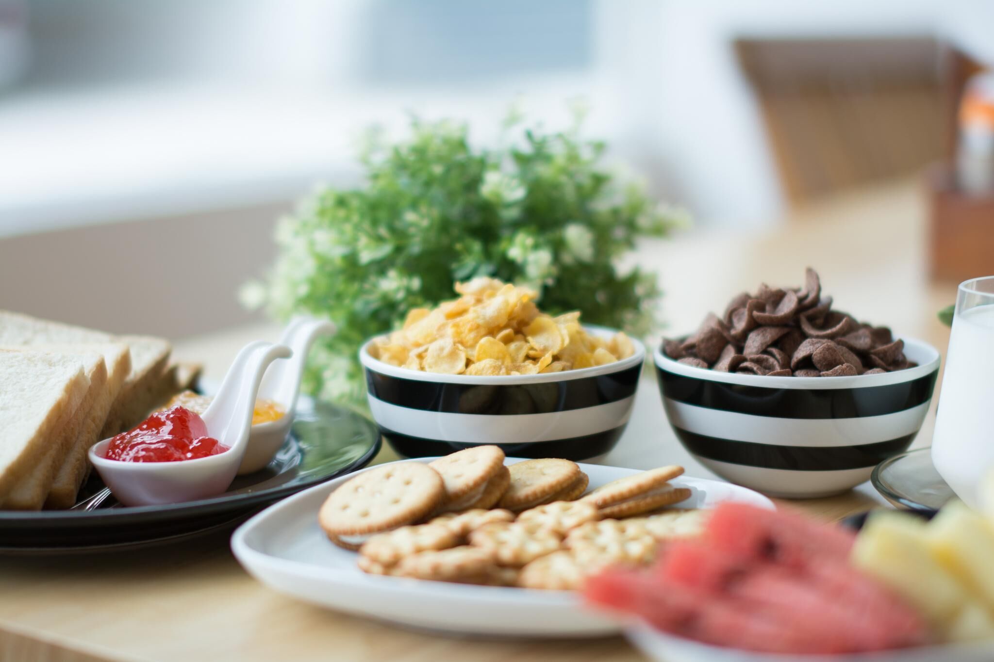 Een tafel met diverse etenswaren, zoals brood, koekjes, chocolade en fruit.