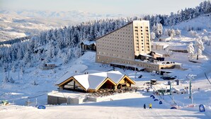 A large hotel with multiple floors, ski slopes, and a snow-covered landscape. - Dorukkaya Ski & Mountain Resort (Seben)