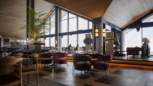 A spacious indoor area with wooden flooring, large windows, and a variety of seating arrangements including chairs and sofas. - Dorukkaya Ski & Mountain Resort (Seben)