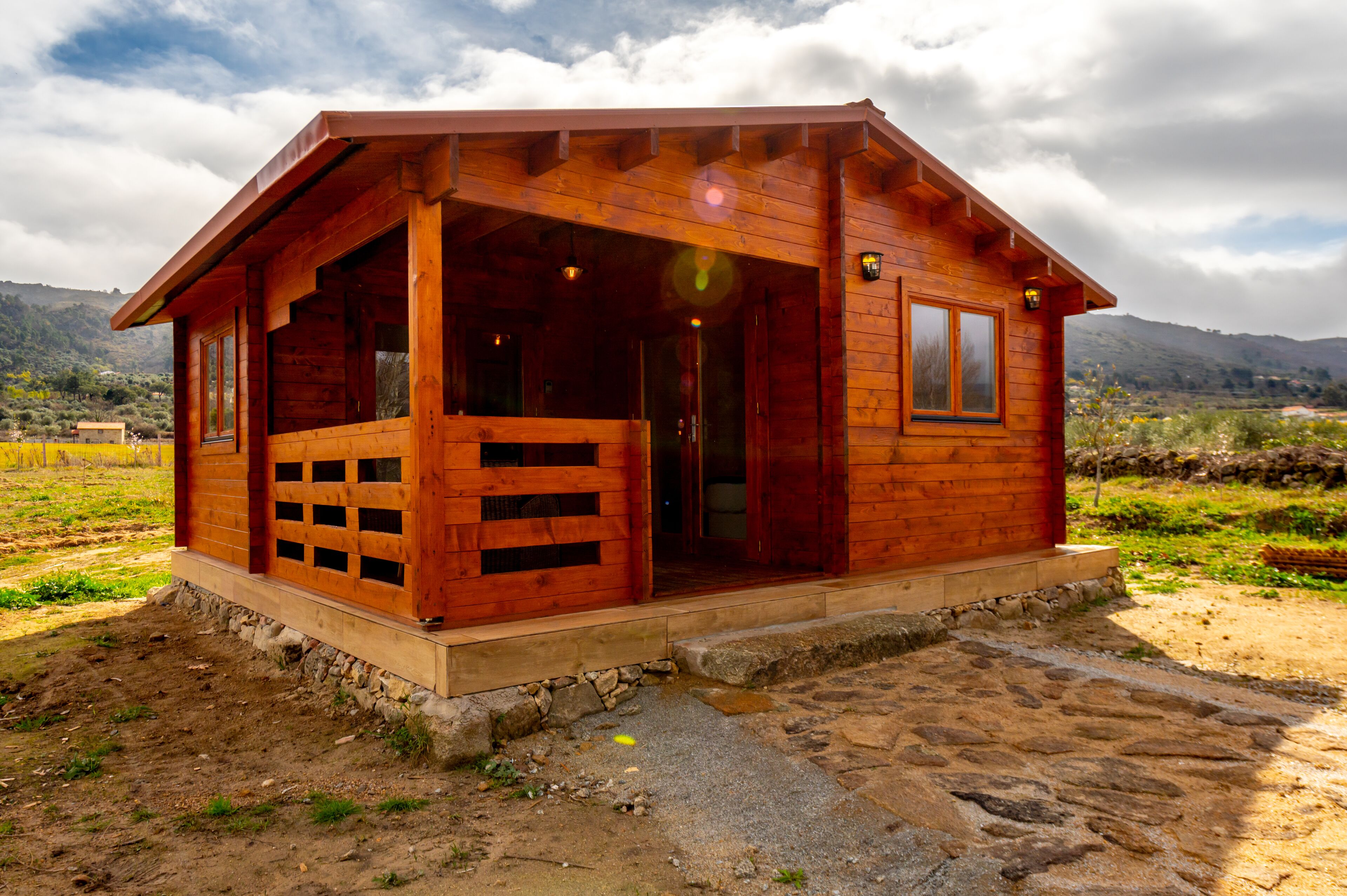 A wooden cabin with a porch, a door, and a window.