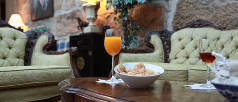 Une table à manger avec un bol de céréales, deux verres de jus d’orange et un verre de vin rouge.