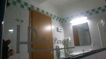 A bathroom with a mirror, a sink, and a door.