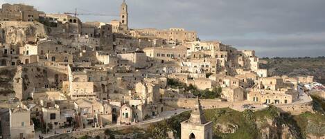 Un pueblo histórico con edificios muy juntos, una torre destacada y una iglesia con campanario.