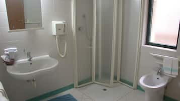 A bathroom with a shower enclosure, a sink, a bidet, and a toilet.