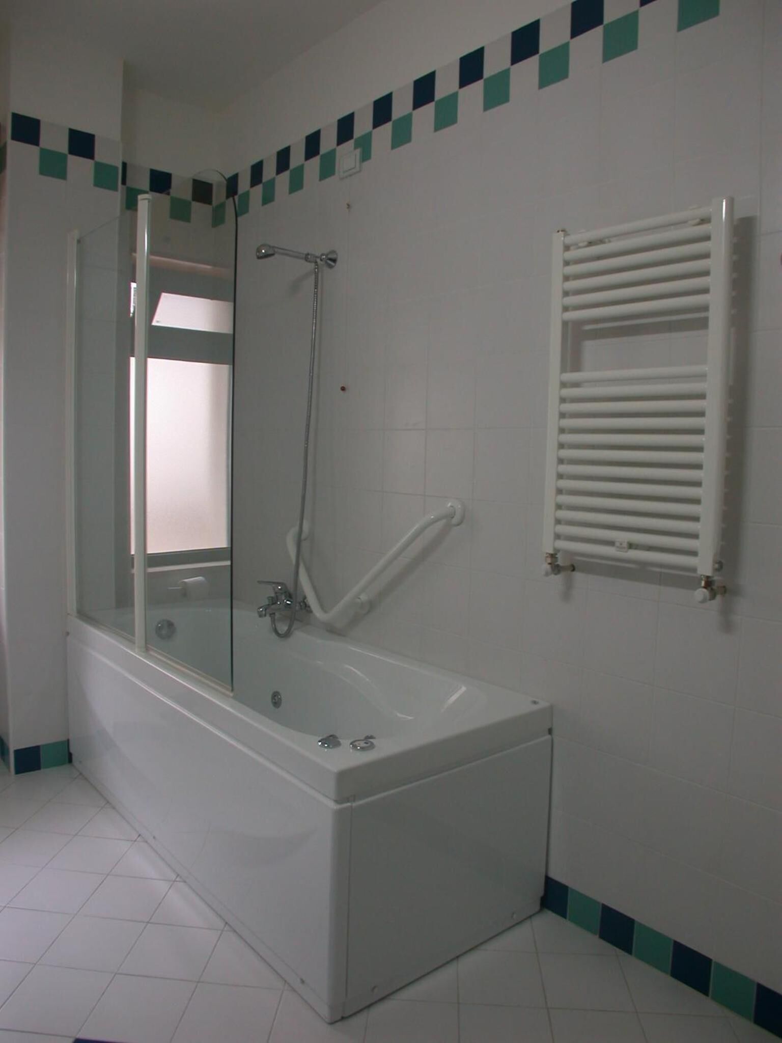 Ein Badezimmer mit Badewanne, einer Duschkabine und einem Handtuchhalter.
