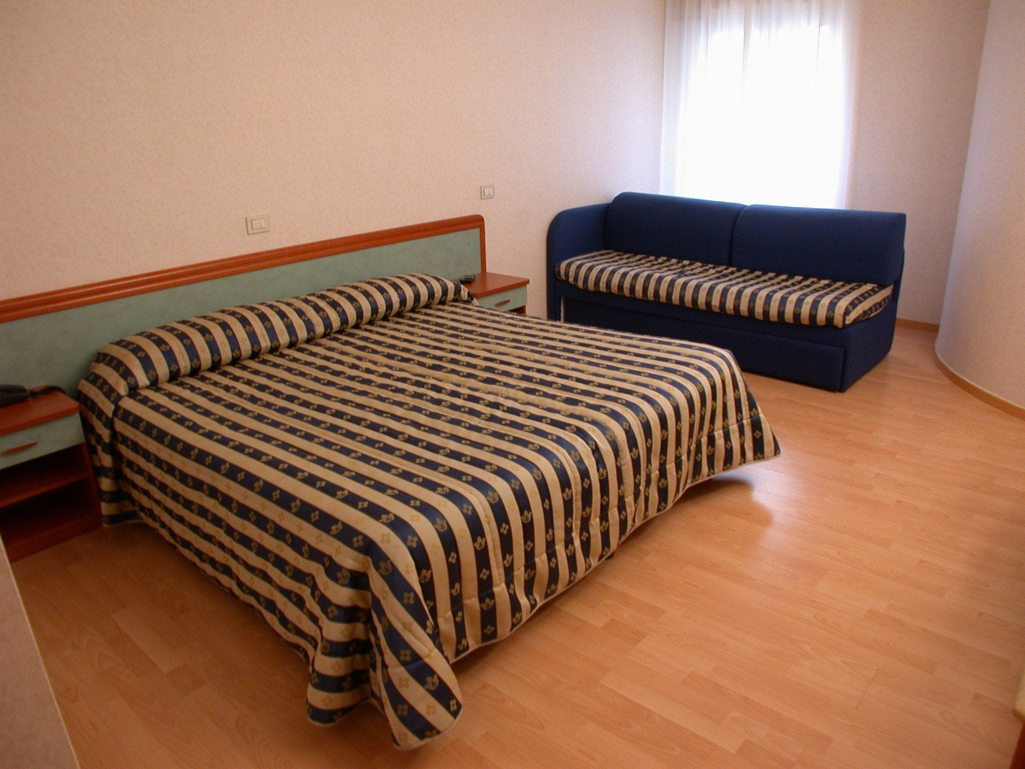 A bedroom with a bed and a sofa.