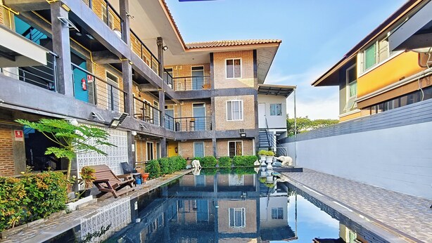 Un edificio moderno con piscina, balcones y cielo despejado.