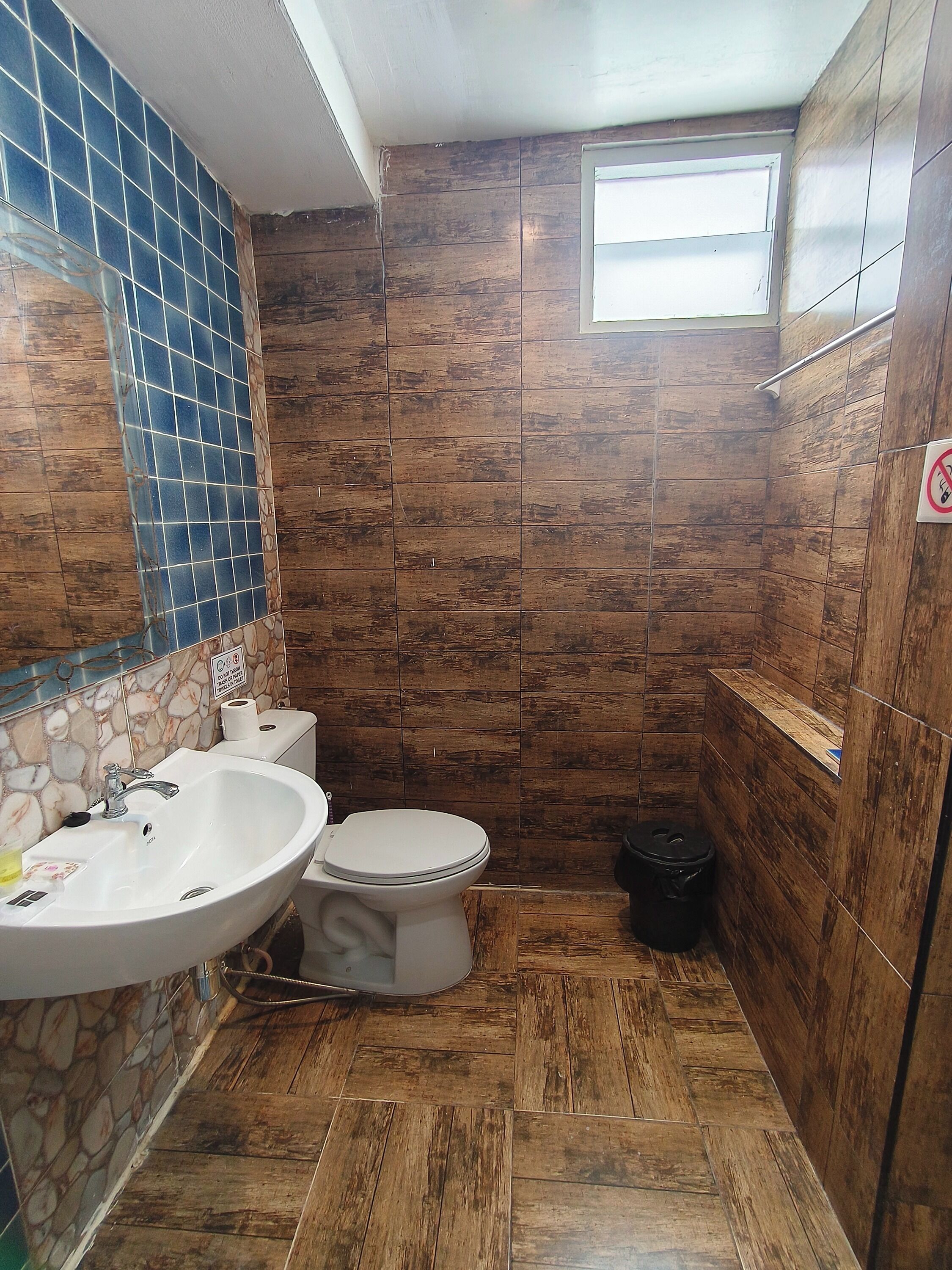 Un baño con lavabo, inodoro y ventana.