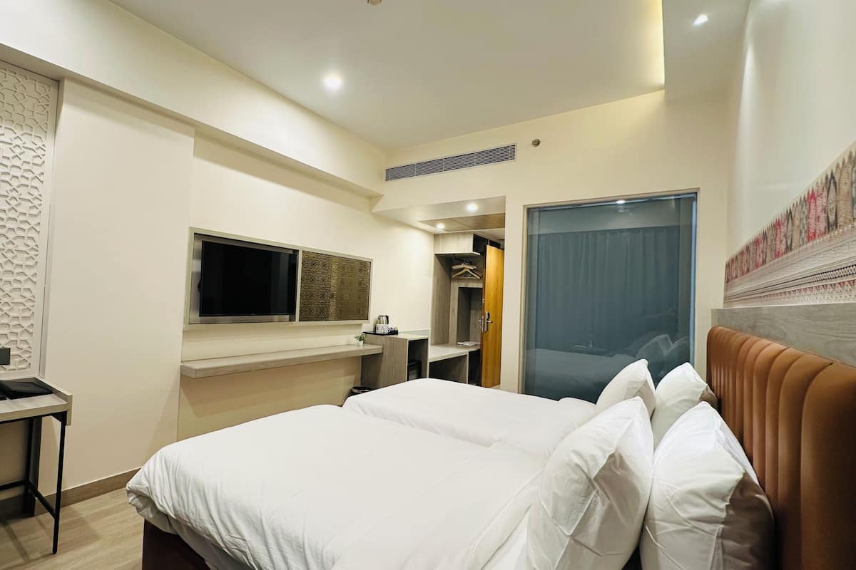 Habitación de hotel con cama, escritorio, televisor y pared con diseño.