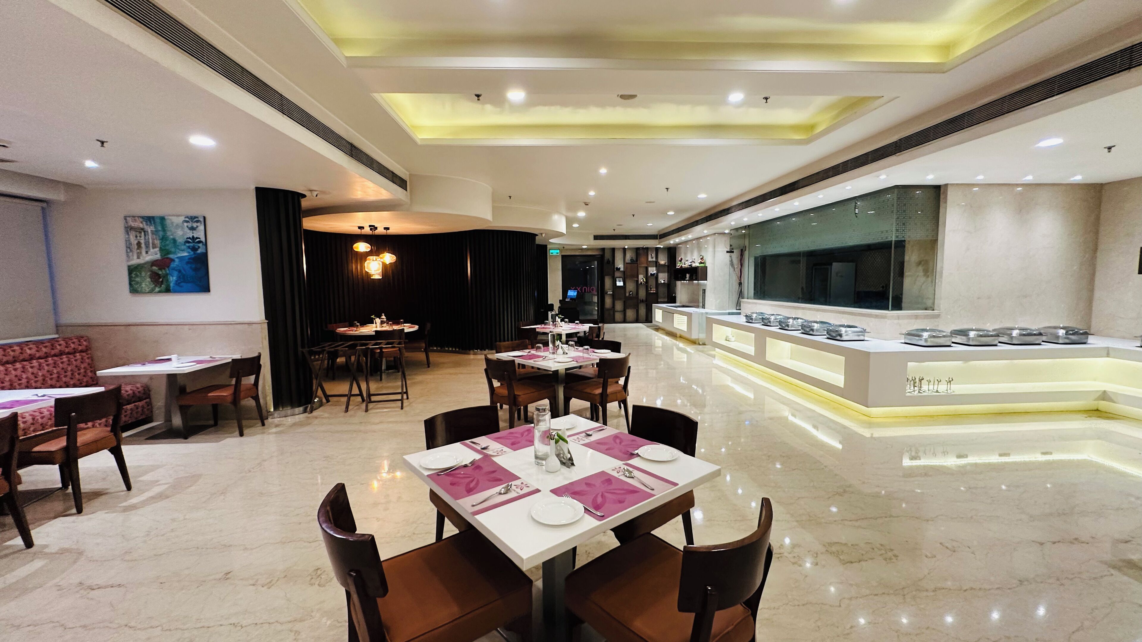 Un restaurant moderne doté d’une salle à manger principale, d’un bar avec un comptoir et d’un espace détente avec des tables et des chaises.