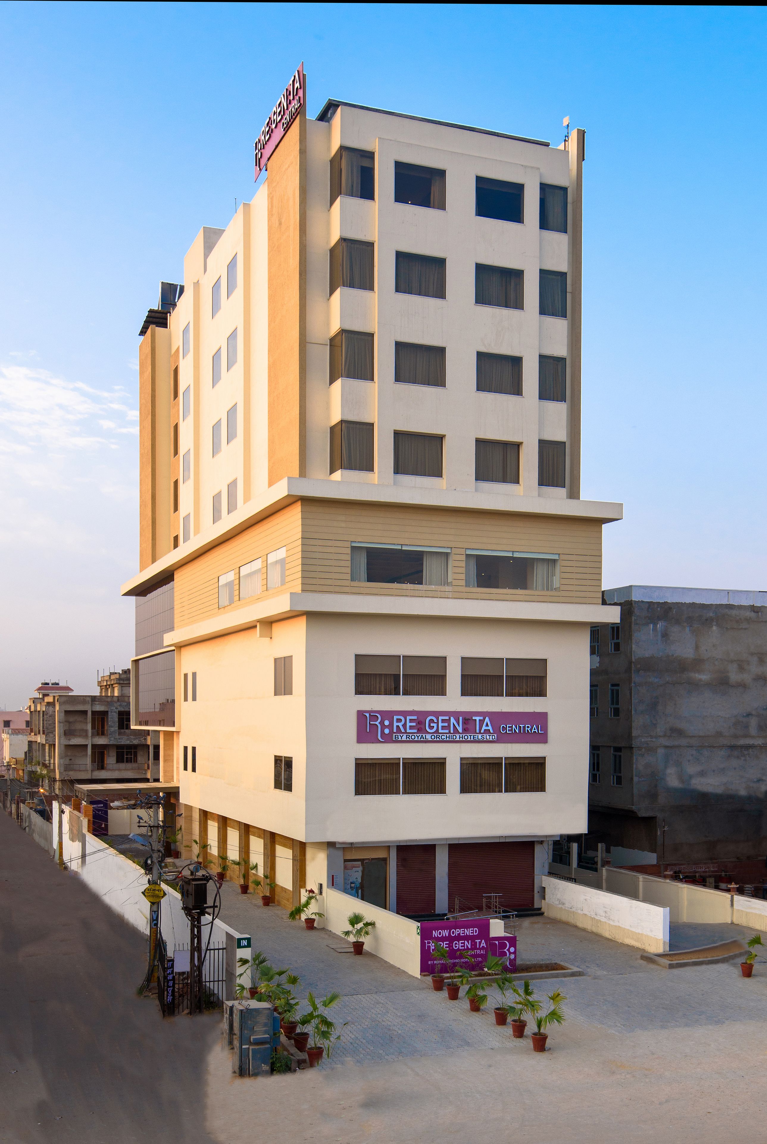 A multi-story hotel with a sign for "RE GEN TA CENTRAL" and "ROYAL ORCHID HOTELS".