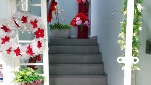 Una escalera con plantas en macetas y flores rojas.