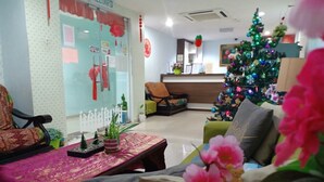Una sala de estar acogedora con un árbol de Navidad, una mesa de recepción y un área de estar con una mesa y sillas.