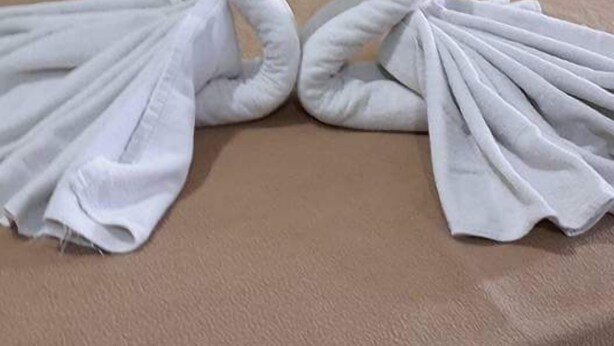 Una cama con toallas dispuestas en forma de corazón.