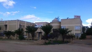 Un edificio con un cartel que indica 'NEST Conference Facility' y 'Nest Lodge'.