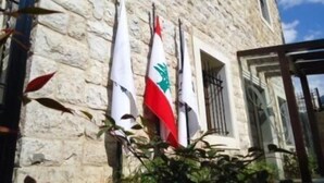 A stone building with three flags, one of which has a green emblem. - Siena Hotel (Ghazir)