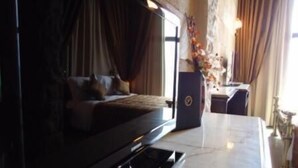 A hotel room with a bed, a desk, and a large window. - Siena Hotel (Ghazir)