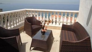 A balcony with wicker furniture and a view of the sea. - Siena Hotel (Ghazir)