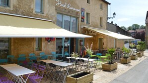 A hotel restaurant with outdoor seating, tables, and chairs. - Auberge de Marville (Marville)