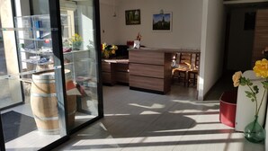 A modern office space with a glass partition, wooden furniture, and a vase with flowers. - Auberge de Marville (Marville)