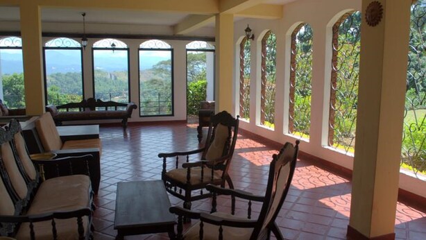 A spacious patio with a view of lush greenery and mountains. - Mahaweli Regent Hotel (Kandy)