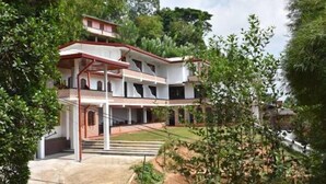 A two-story building with a covered entrance and a staircase leading to the upper floor. - Mahaweli Regent Hotel (Kandy)