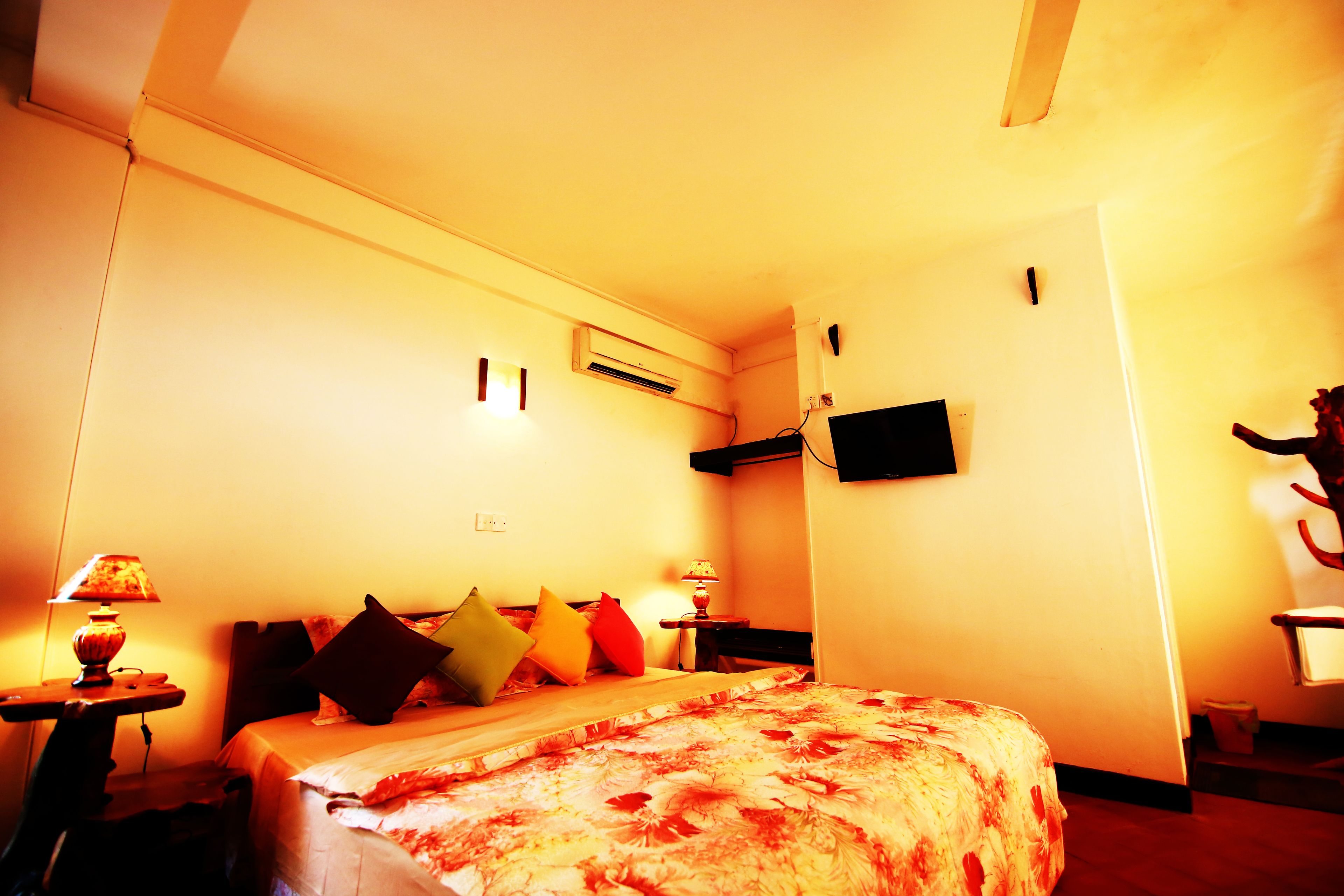 Une chambre d’hôtel équipée d’un lit, d’un bureau, d’une chaise, d’une télévision et d’une lampe.