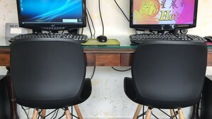 Two computer monitors on a desk with a keyboard and mouse, connected to a power outlet. - CK Hotel (Malacca City)