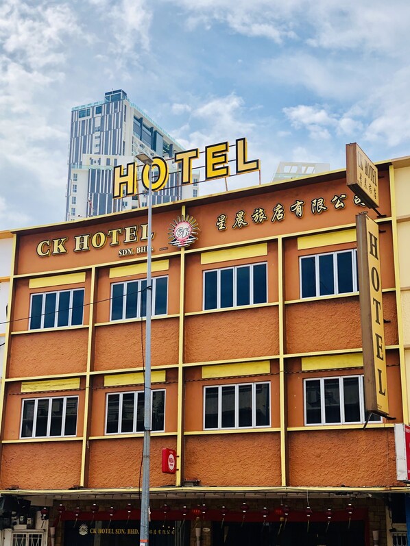 Un edificio de hotel con un letrero que dice "CK HOTEL" y un logotipo sobre la entrada.