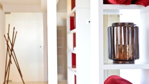 Un intérieur moderne avec une porte blanche, un chevalet en bois et un porte-bougie en métal posé sur une étagère.