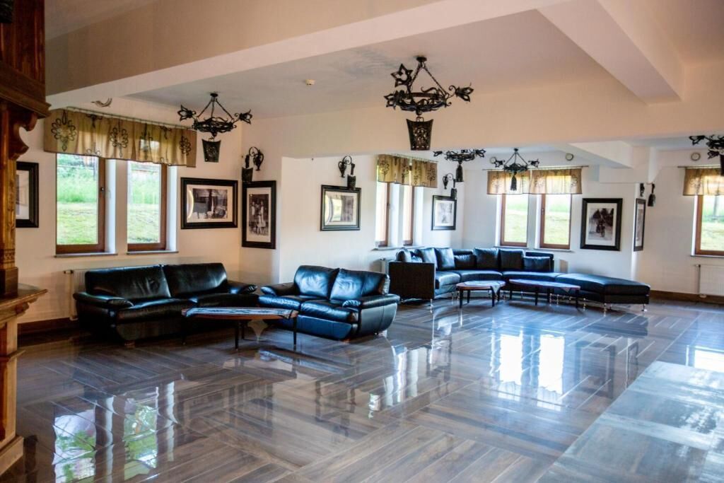 A spacious living room with a large sectional sofa, a fireplace, and a chandelier.
