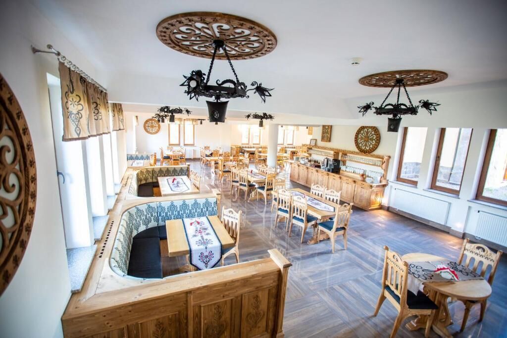 Uma ampla sala de jantar com mobiliário de madeira e decoração de teto elaborada.