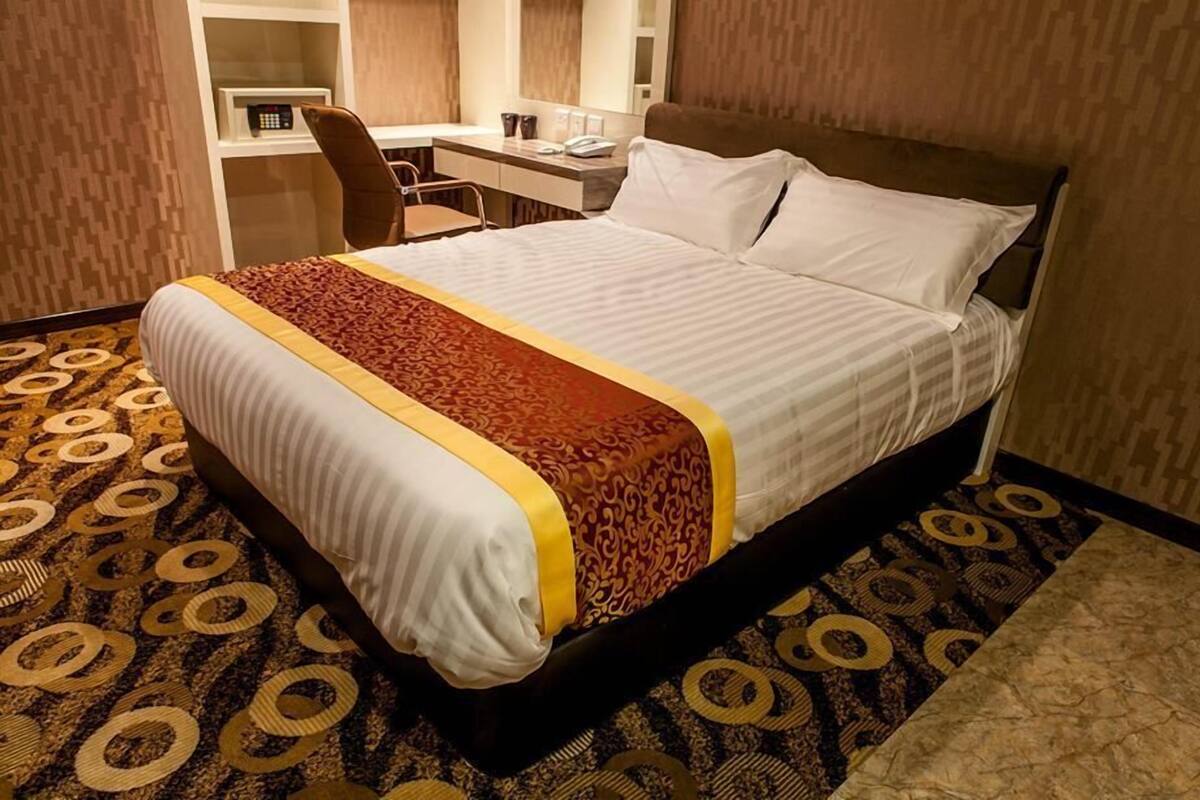 Una habitación de hotel con una cama grande, un escritorio y una silla.