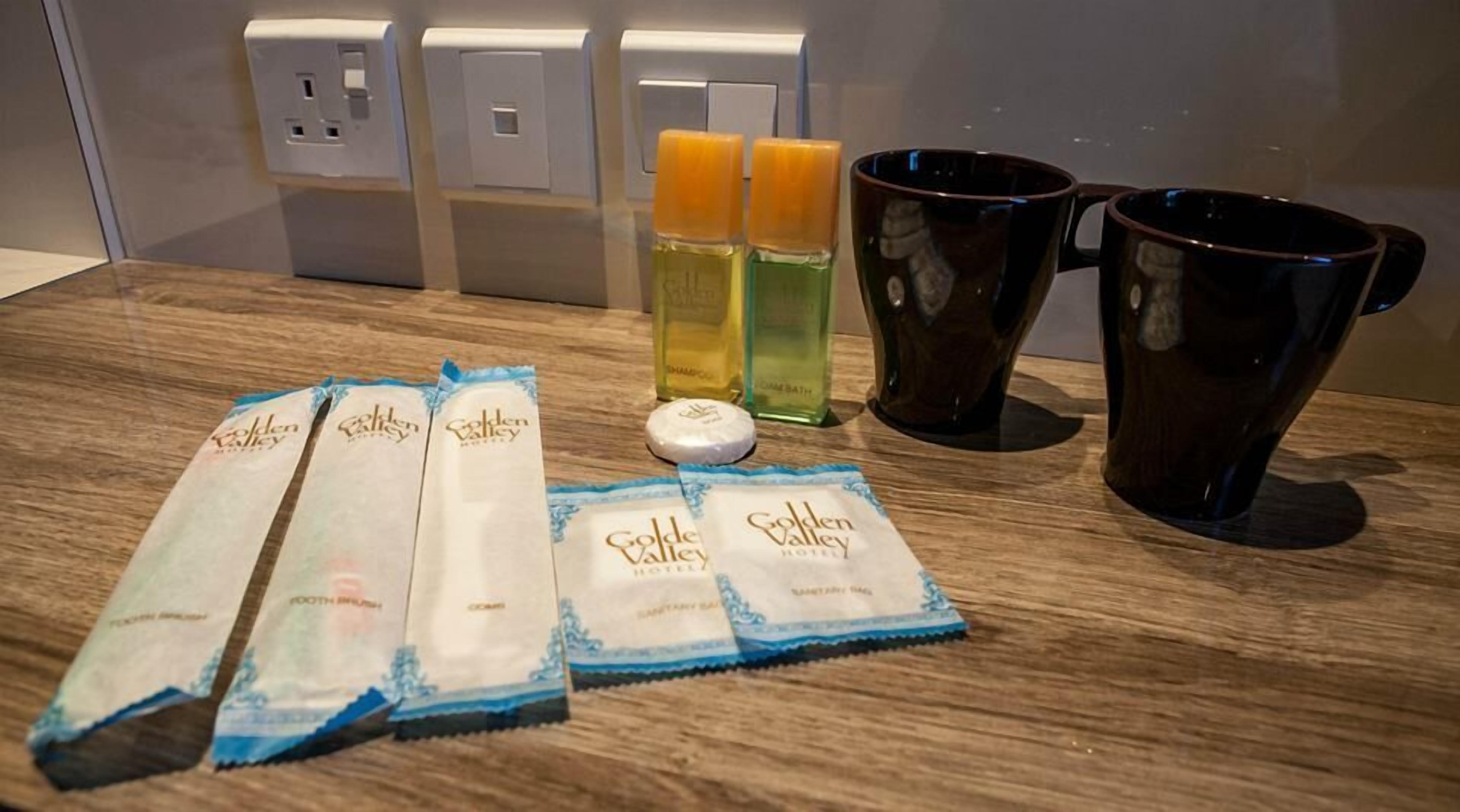 Toiletries including shampoo, conditioner, and a bar of soap on a hotel counter.