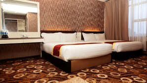 A hotel room with two beds, a large mirror, a minibar, and a patterned carpet. - Golden Valley Hotel (Malacca City)
