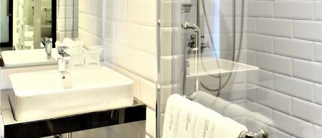 Ein modernes Badezimmer mit einer Duschkabine aus Glas, einem weißen Waschbecken und einer schwarzen Arbeitsplatte.