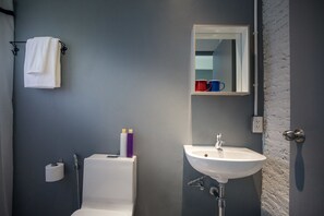 A bathroom with a white toilet, a sink, a towel rack, and a mirror. - W1A Jomtien (Pattaya)